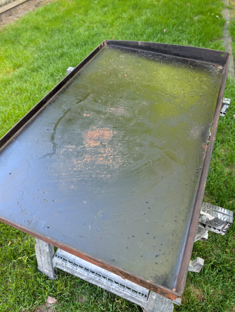 Side view of neglected Blackstone griddle showing overall condition before restoration