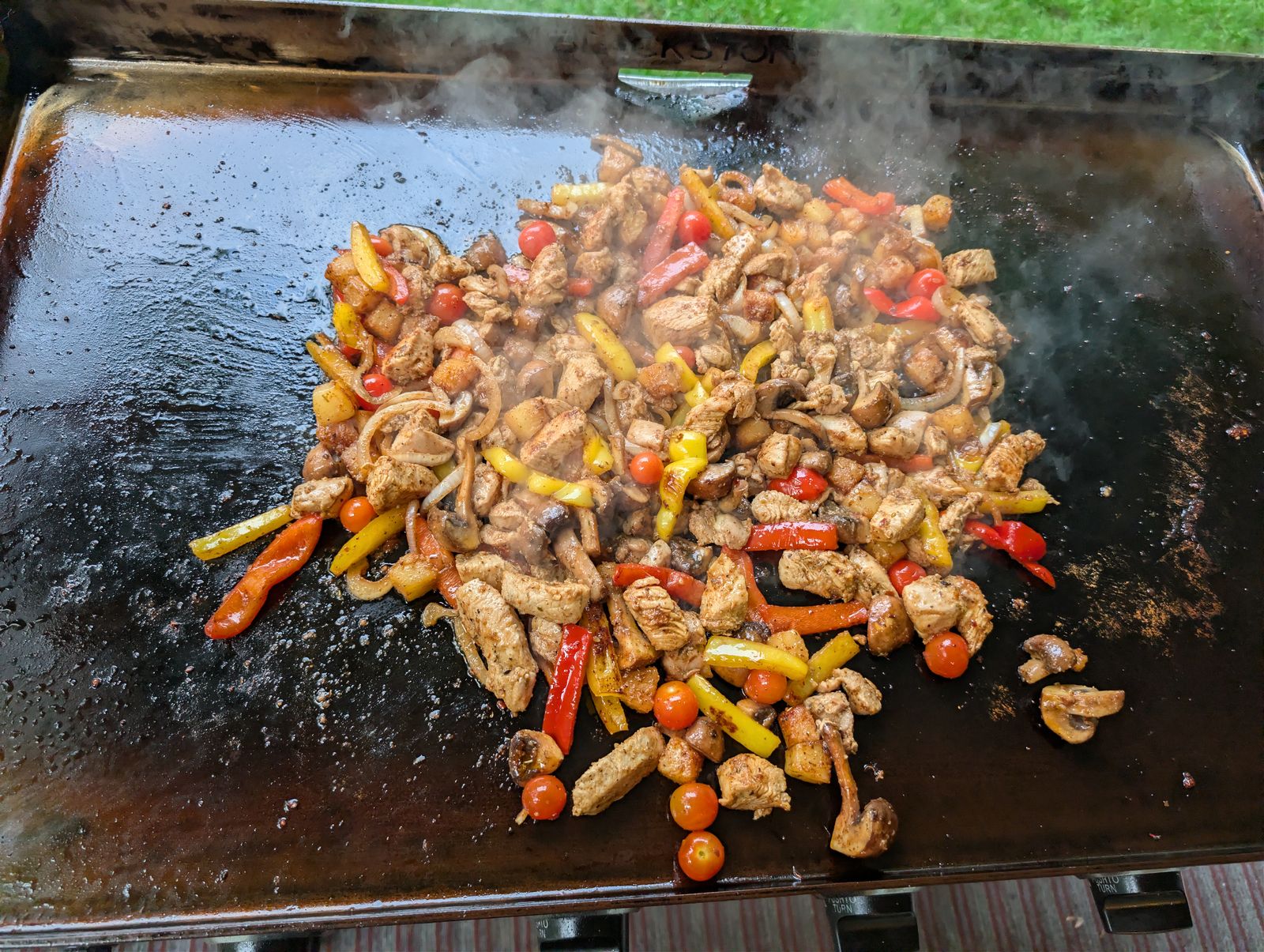Papa's Chicken Sh#t on the Blackstone griddle, chicken, peppers, mushrooms, and cherry tomatoes, all mixed and steaming