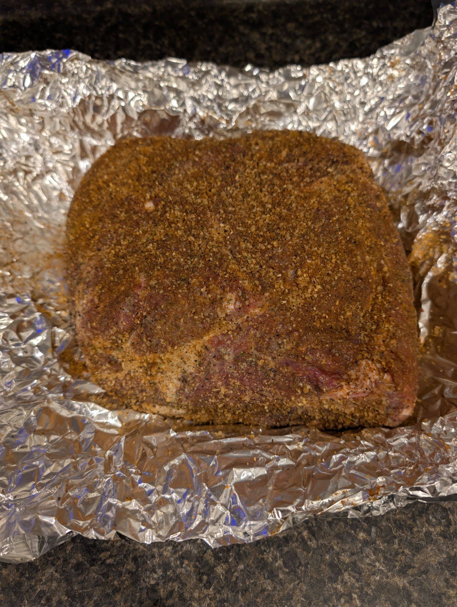 Raw pork shoulder seasoned for pulled pork