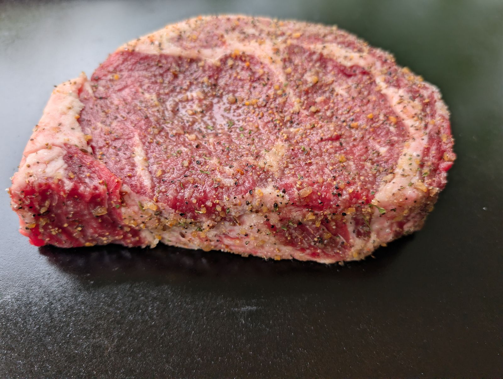 Ribeye steak seasoned with Montreal Steak Seasoning ready for the pellet grill