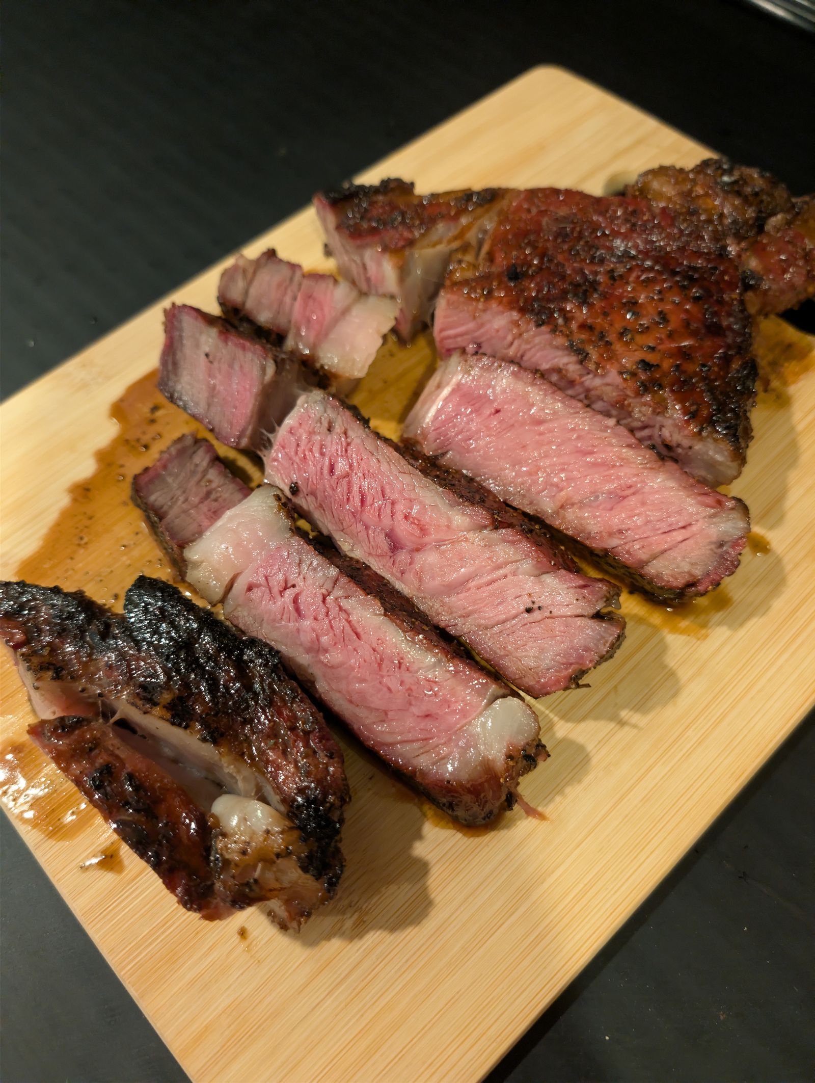Reverse seared ribeye sliced to show the edge-to-edge medium-rare center